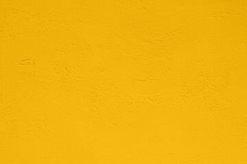 Saturated pastel yellow colored low contrast Concrete textured background. Empty colourful wall texture with copy space for text overlay and mockups. 2023, 2024 color trend