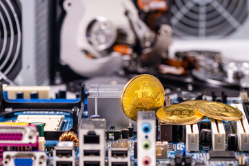 closeup of gold bitcoin on computer components background, technology and digital currency concept