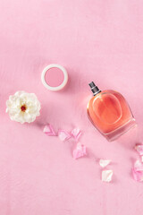 Cosmetic banner with a rose perfume and makeup, shot from above on a pink background with copy space