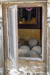 The open window of the Buddhist temple Wat Khun Samut Chin, a look at traditional stone balls Luk nimit - obrazy, fototapety, plakaty