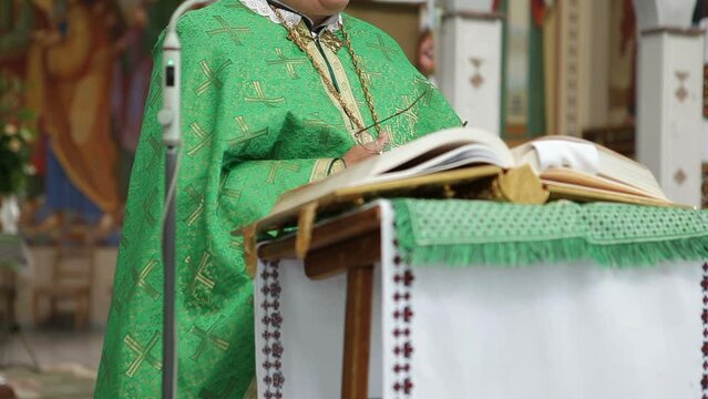 An Orthodox priest reads the Bible in a church and preaches while standing in front of the parishioners. Liturgy in the church.