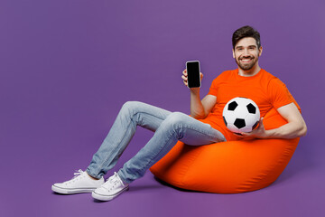 Full bodyyoung man he wear orange t-shirt cheer up support football sport team hold soccer ball...