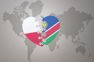 puzzle heart with the national flag of namibia and poland on a world map background.Concept.