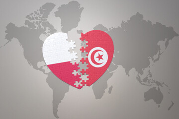 puzzle heart with the national flag of tunisia and poland on a world map background.Concept.