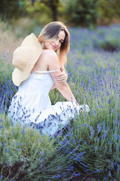 Girl on Summer Walks in her free time in Lavender Glade.Vertical Photo Woman Crouched Among Lavender