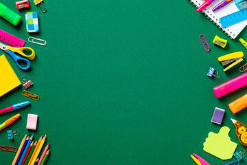 Back to school concept. Frame made of colorful school supplies on green background. Flat lay, top view, copy space. - obrazy, fototapety, plakaty