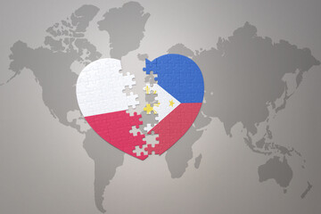 puzzle heart with the national flag of philippines and poland on a world map background.Concept.