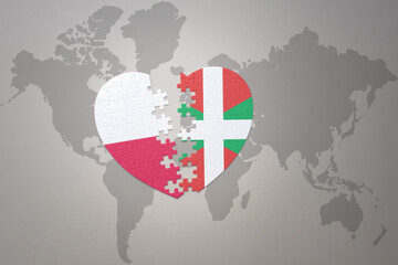 puzzle heart with the national flag of basque country and poland on a world map background.Concept.