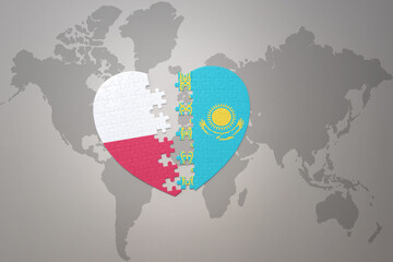 puzzle heart with the national flag of kazakhstan and poland on a world map background.Concept.
