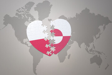 puzzle heart with the national flag of greenland and poland on a world map background.Concept.