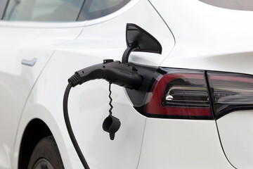 Fototapeta premium Charging electric car on the city street. Parking with charger.