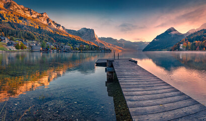 Fishing pier in the calm pond. Picturesque autumn view of Grundlsee lake. Wonderful morning scene...