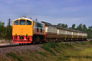 Fototapeta premium Passenger train by diesel locomotive on the railway in Thailand