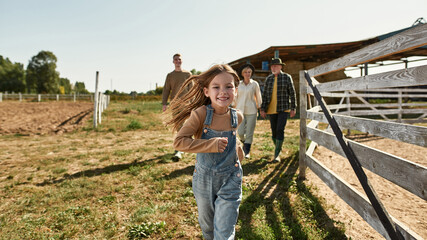 Girl run while her grandparents and brother walk