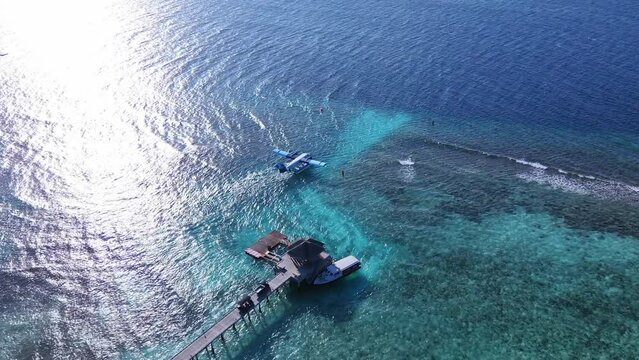 Seaplane on the runway, get ready to take off. Tropical atoll island in Maldives with coral reef and turquoise sea water. Touristic vacation holidays travel destination. Scenic seascape. Vakkaru