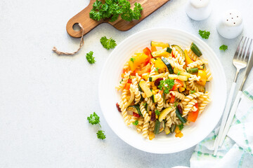 Vegan pasta with vegetables. Healthy vegetarian dish. Top view on white.