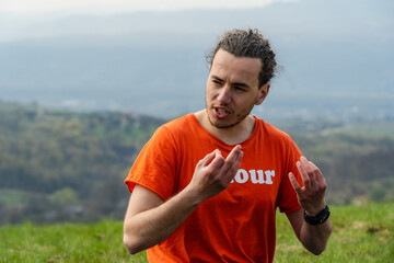 Fototapeta premium Man sitting on the mountain and telling something