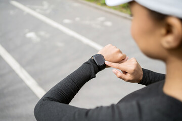 Uses a fitness bracelet tracker watch on her arm, a sporty woman does a workout,