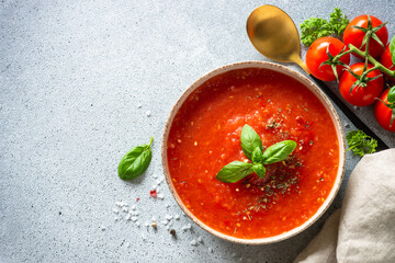 Tomato soup. Traditional vegetable soup with ingredients. Top view on light stone table.