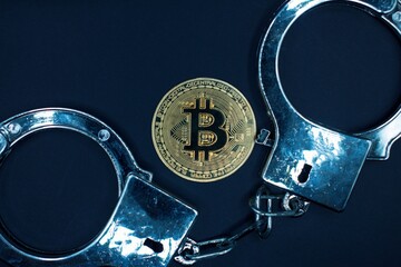 Bitcoin with handcuffs , concept of illegal affair .
