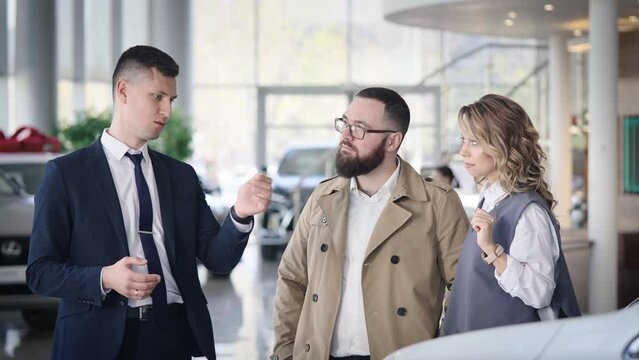 Sales manager in a car dealership serves a married couple. A man and a woman choose a new car