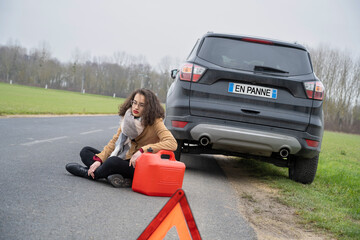 femme en panne d'essence sur le bord de la route