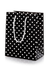 Black package for shopping or gifts with white handles and dots.