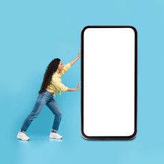 Fototapeta na wymiar Lady Posing With Huge Cellphone Blank Screen Over Blue Background