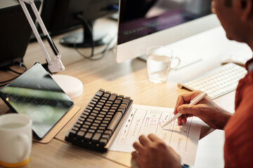Front end developer drawing wireframe of website at office desk