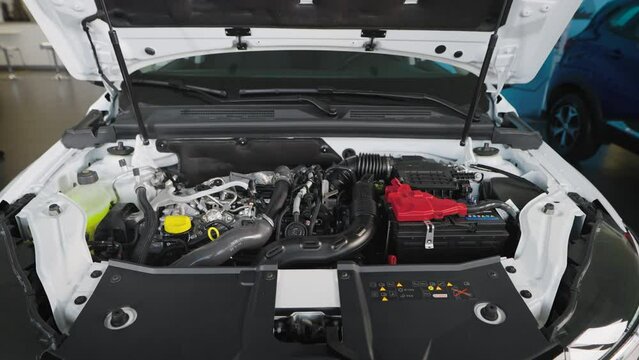Car engine under the hood of a modern car. New car in the showroom.