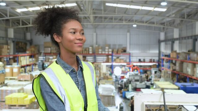 Female warehouse worker counting items in an industrial warehouse on the factory's mezzanine floor. which is a storage for small and light electronic parts.