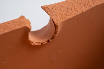 Broken terracotta pot close up on isolated white background. Manufactured defect. Shipment risk.