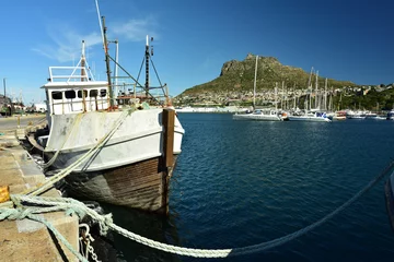Fototapeten A weathered vessel in Hout Bay harbor on a sunny day © Gerrit Rautenbach