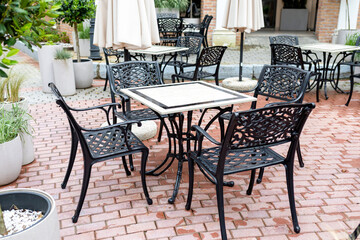 Wet empty tables and chairs in the outdoor cafeteria after the rain