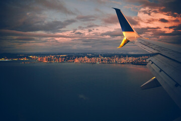 View from the airplane window on a beautiful sunset and clouds of Panama City