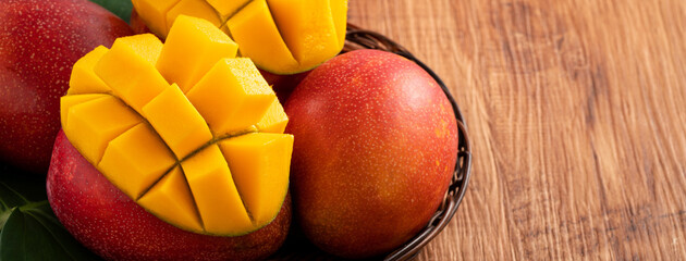 Mango. Fresh mango fruit with leaves over dark wooden table background.