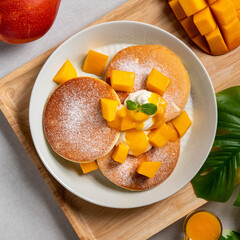 Delicious Japanese souffle pancake with dice mango and jam on white table background.