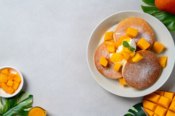 Delicious Japanese souffle pancake with dice mango and jam on white table background.