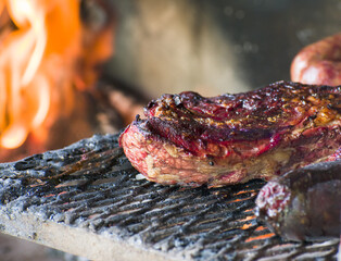 Delicious cut of rump tail cooked on an Argentine grill surrounded by sausages and blood sausages....