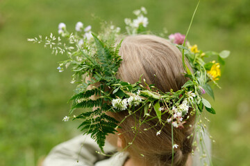 Naklejka premium A wreath on a child's head, unity with nature.