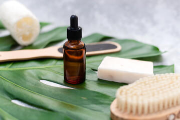 Natural cosmetics for bathing on the background of a palm leaf. Body moisturizing soap, serum and...