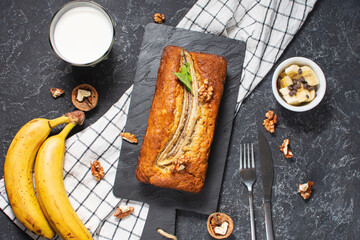 Banana bread or cake on black stone table. Delicious homemade dessert, tasty snack or morning...