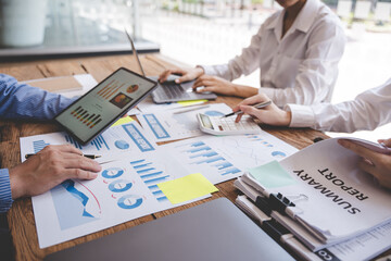 Young colleagues discussing business and price chart analyzes business people on the table great in modern coworking office teamwork concept.
