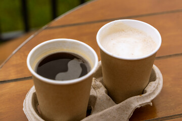 paper cups with coffee on the table of an outdoor cafe. Takeaway food.