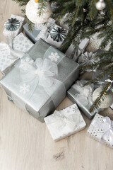 White and silver gift boxes with bows under the Christmas tree, Merry Christmas and Happy New Year