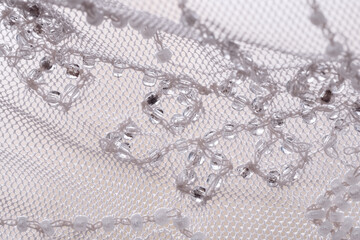 Lace skirt decoration, beadwork, close-up, selective focus. Beads thread clothing detail, macro