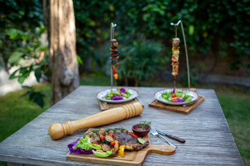 Shish kebab BBQ chicken meat with onions and tomatoes at the restaurant. Free space for your text.