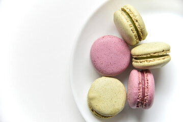 Macaroons. Sweet French desserts. Macaroons on a white plate. Macaroons on the table in the afternoon.