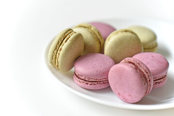 Macaroons. Sweet French desserts. Macaroons on a white plate. Macaroons on the table in the afternoon.