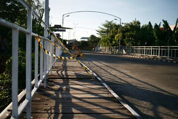 Metal fence in wooden bridge. Caution tape black and yellow line striped in wooden bridge